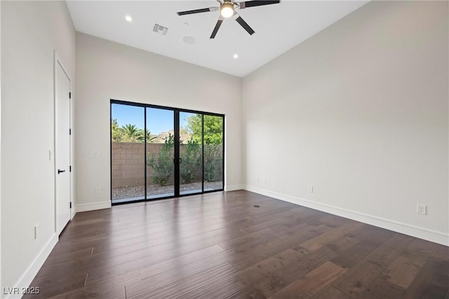 spare room with a high ceiling, ceiling fan, and dark hardwood / wood-style floors