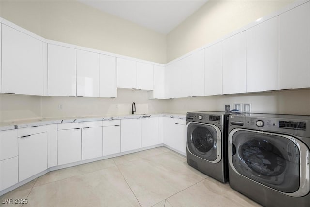 clothes washing area featuring cabinets, light tile patterned floors, sink, and independent washer and dryer