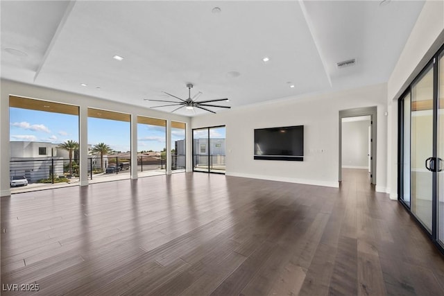 unfurnished living room featuring dark wood-type flooring and ceiling fan