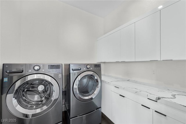 washroom featuring cabinets and independent washer and dryer