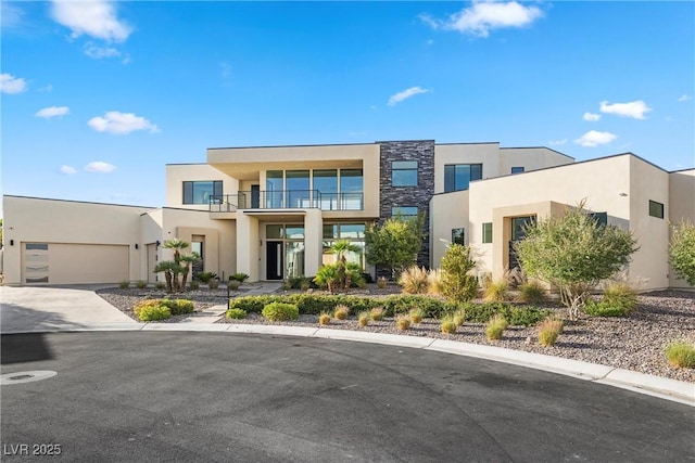 contemporary house featuring a garage and a balcony