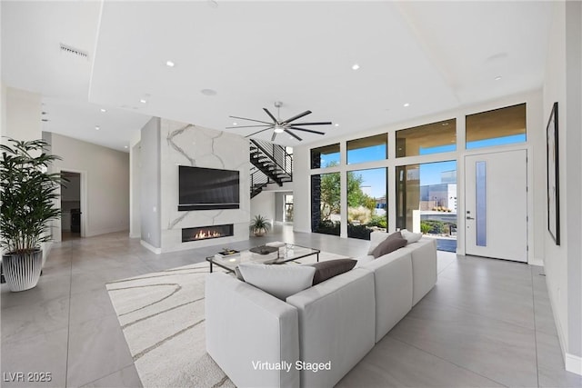 living room with ceiling fan and a premium fireplace