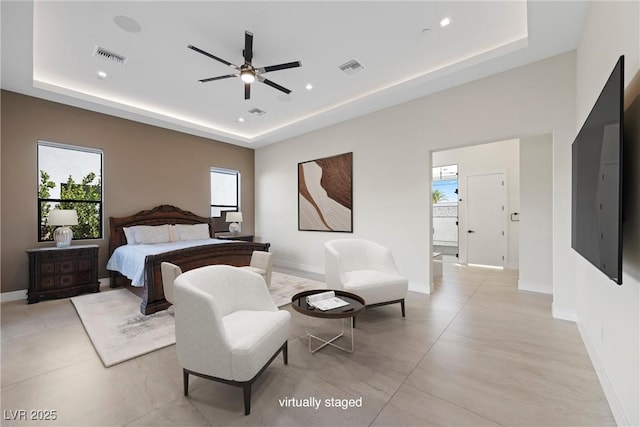 bedroom with ceiling fan and a tray ceiling