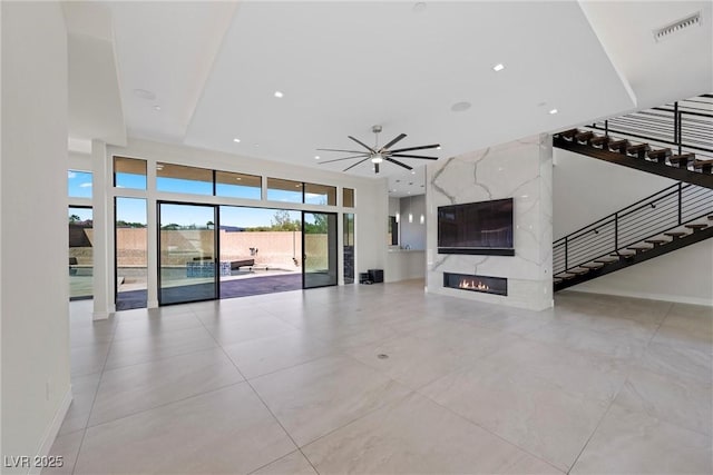 unfurnished living room with ceiling fan and a premium fireplace