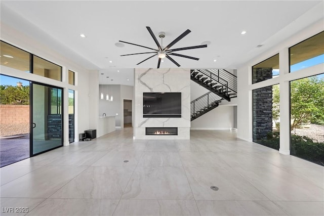 unfurnished living room featuring ceiling fan and a fireplace