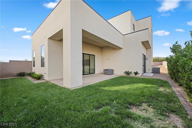 back of property with central air condition unit, a lawn, and a patio