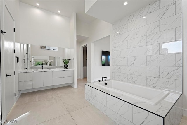 bathroom featuring vanity and a relaxing tiled tub