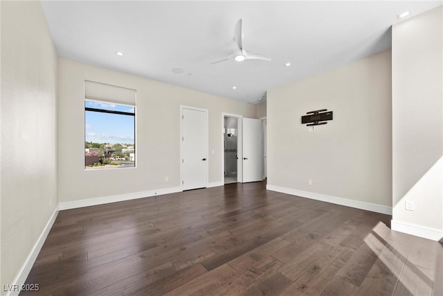 unfurnished room with ceiling fan and dark wood-type flooring