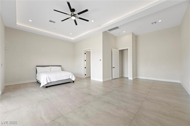 unfurnished bedroom featuring ceiling fan and a raised ceiling