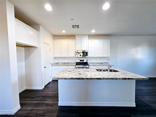 846 Star Estates Ave, North Las Vegas, NV 89086 - kitchen featuring appliances with stainless steel finishes, a sink, baseboards, a center island with sink, and light stone counters
