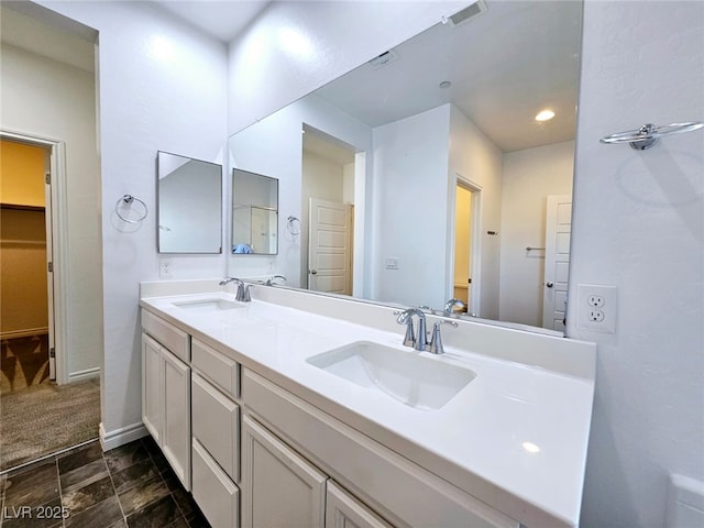 846 Star Estates Ave, North Las Vegas, NV 89086 - bathroom featuring double vanity, a spacious closet, recessed lighting, and baseboards