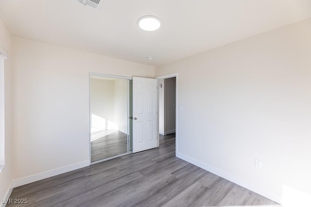 unfurnished bedroom with a closet and hardwood / wood-style flooring