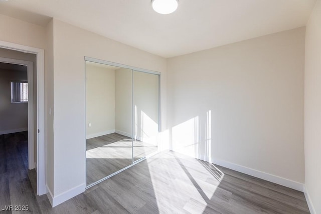 unfurnished bedroom with a closet and hardwood / wood-style flooring