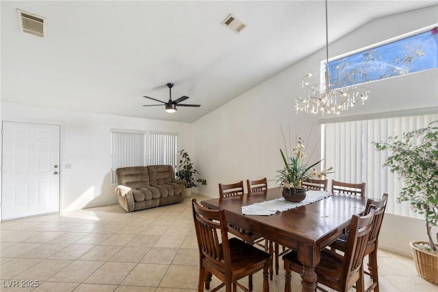 dining room with vaulted ceiling, light tile patterned floors, a healthy amount of sunlight, and ceiling fan with notable chandelier