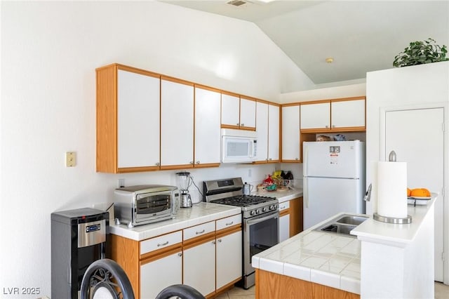 kitchen with white cabinetry, lofted ceiling, a kitchen island, and white appliances