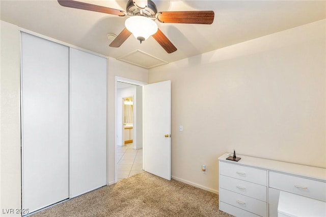 unfurnished bedroom with a closet, light colored carpet, and ceiling fan