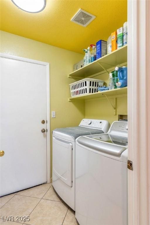 washroom featuring light tile patterned flooring and washing machine and clothes dryer