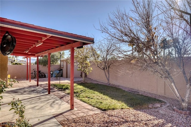 view of yard featuring a storage unit and a patio area