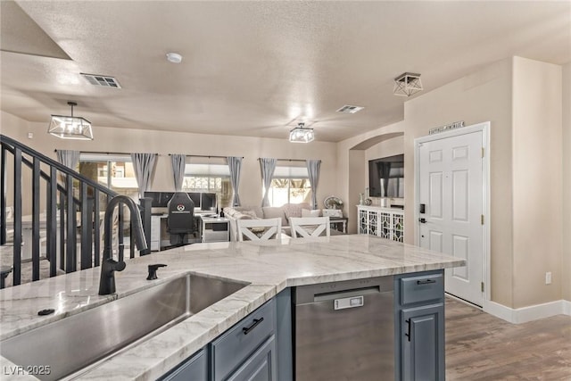 kitchen featuring dishwasher, dark hardwood / wood-style flooring, sink, hanging light fixtures, and gray cabinetry