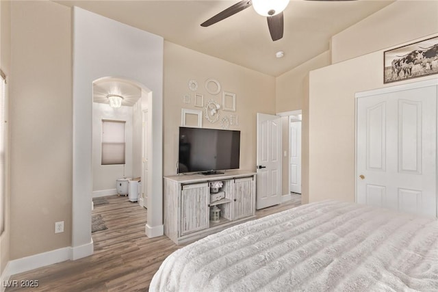 bedroom with ceiling fan, lofted ceiling, and light hardwood / wood-style floors