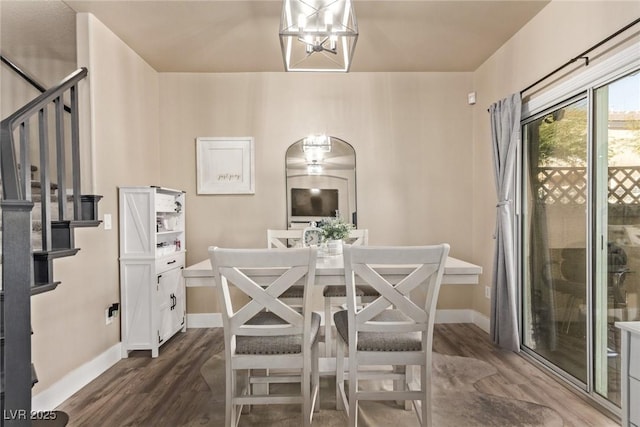 dining area with dark hardwood / wood-style flooring and an inviting chandelier