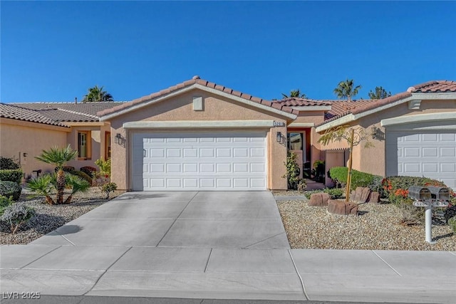 view of front of house featuring stucco siding, an attached garage, driveway, and a tiled roof