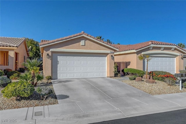 mediterranean / spanish home with stucco siding, a garage, concrete driveway, and a tile roof