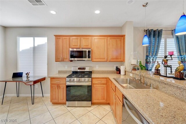 kitchen featuring decorative light fixtures, plenty of natural light, sink, and stainless steel appliances