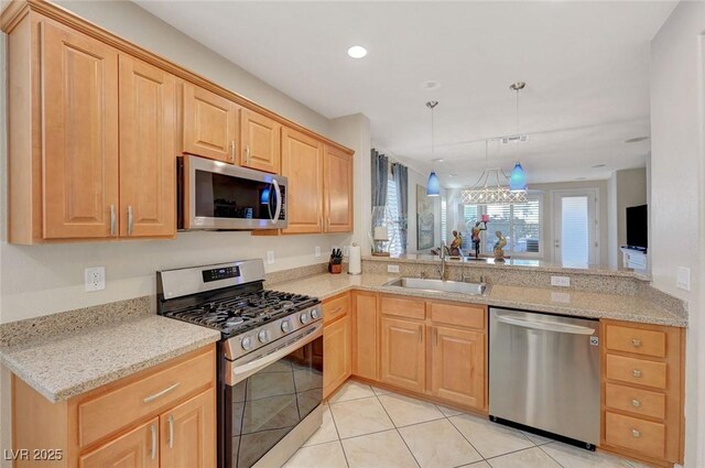 kitchen featuring light tile patterned floors, kitchen peninsula, appliances with stainless steel finishes, hanging light fixtures, and sink