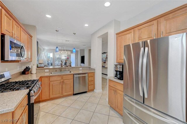 kitchen featuring pendant lighting, appliances with stainless steel finishes, sink, kitchen peninsula, and light tile patterned floors