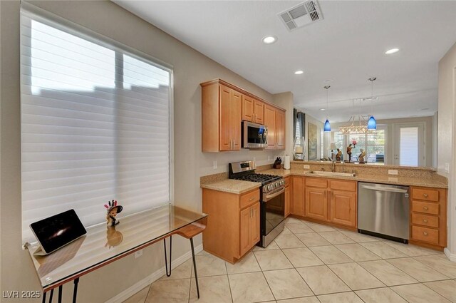 kitchen featuring stainless steel appliances, sink, hanging light fixtures, kitchen peninsula, and light tile patterned floors