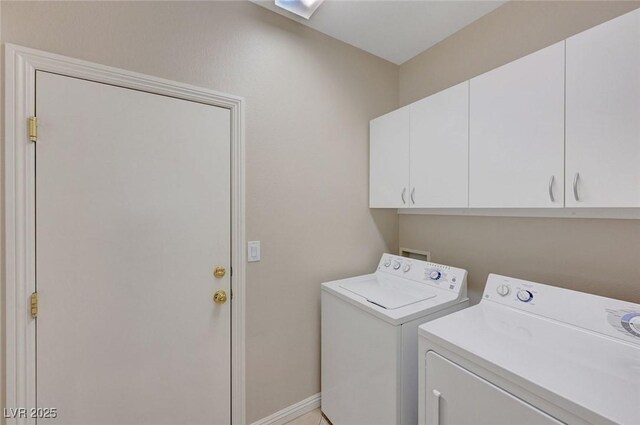 clothes washing area with washer and dryer and cabinets