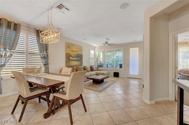 tiled dining space with ceiling fan with notable chandelier