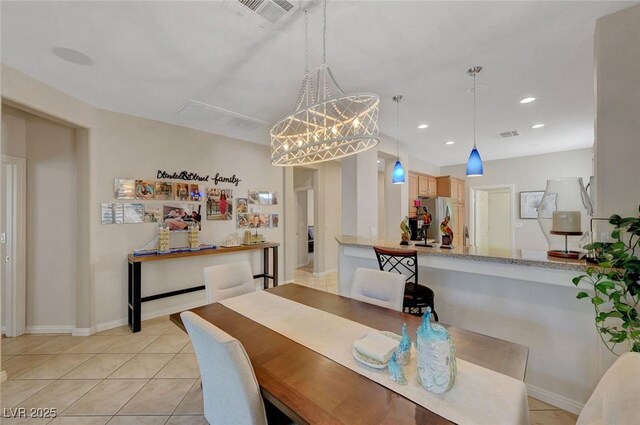 tiled dining area featuring an inviting chandelier