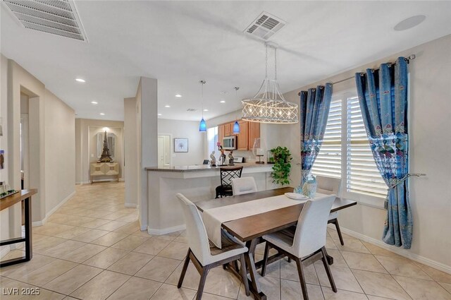 dining area with an inviting chandelier and light tile patterned flooring