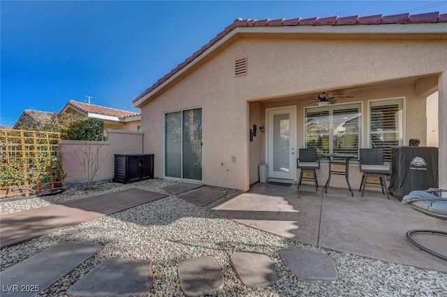 back of house with ceiling fan and a patio