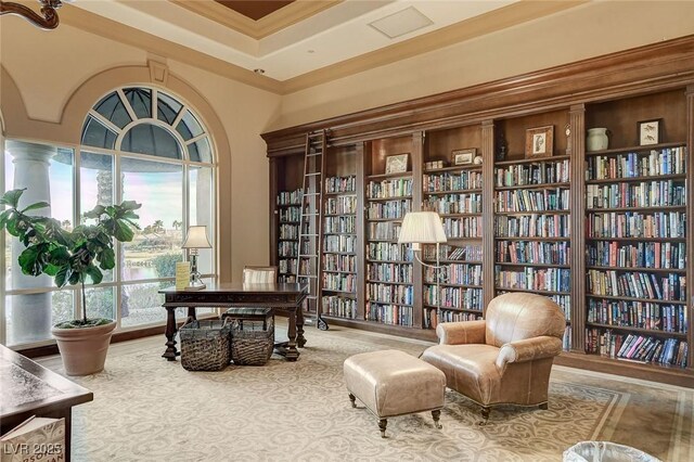 living area featuring a towering ceiling and crown molding