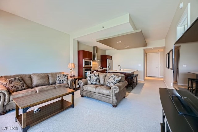 living room featuring light colored carpet and sink