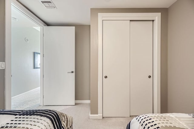 bedroom featuring light colored carpet and a closet