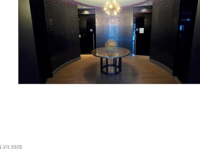 dining area with dark wood-type flooring and an inviting chandelier