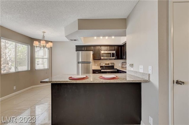 kitchen with light tile patterned floors, stainless steel appliances, a chandelier, and kitchen peninsula