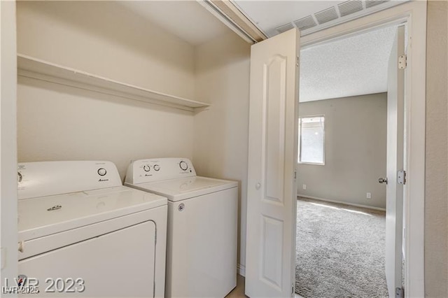 laundry area with independent washer and dryer, a textured ceiling, and carpet flooring