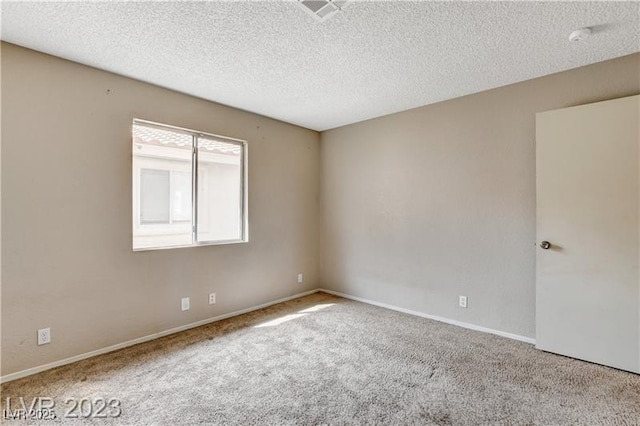 unfurnished room with light carpet and a textured ceiling