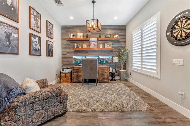 office space with wood-type flooring, a healthy amount of sunlight, and wooden walls