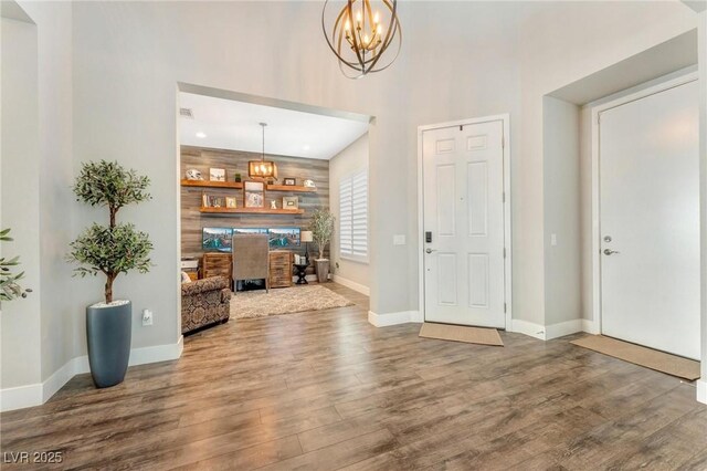 foyer entrance with wood-type flooring and an inviting chandelier