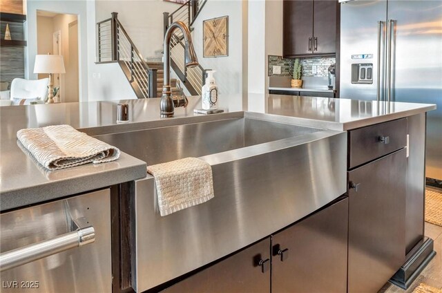 kitchen with decorative backsplash, dark brown cabinets, and high end fridge