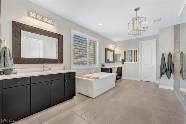 bathroom featuring an inviting chandelier, tile patterned flooring, shower with separate bathtub, and vanity