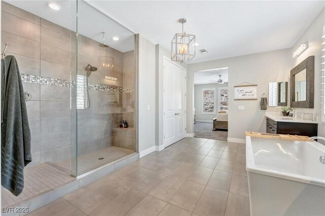 bathroom with vanity, tile patterned flooring, ceiling fan with notable chandelier, and tiled shower