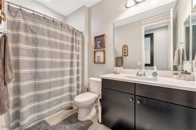 bathroom featuring toilet, tile patterned floors, and vanity