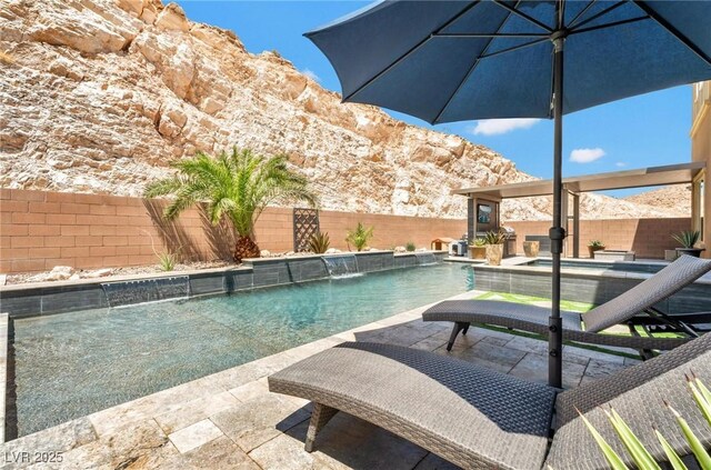 view of swimming pool featuring pool water feature, a patio area, and a mountain view